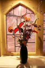A vase of flowers in an arched window