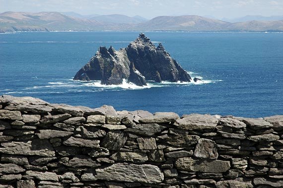 Little Skellig rising from the sea, seen over a stone wall