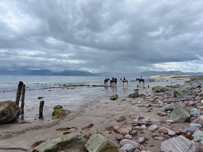 Horse riders on the beach at low tide
