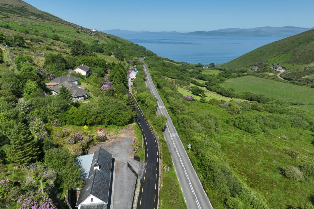 The new Greenway path beside the road above Dingle Bay, among green fields and rhododendrons