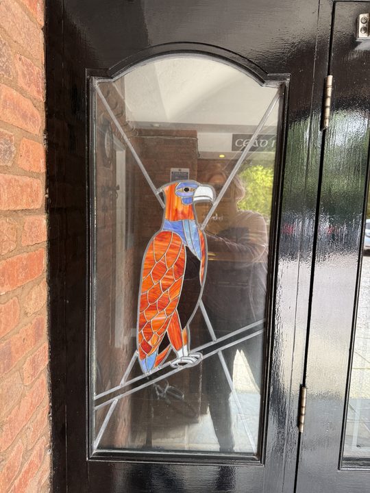 A stained-glass bird in the front door
