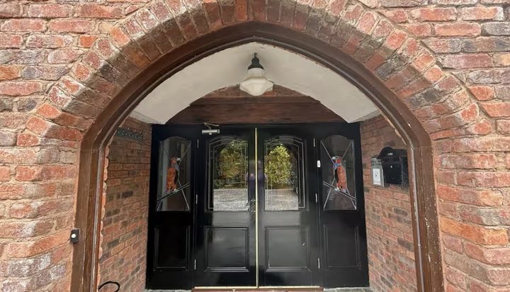 The arched brick doorway with double doors